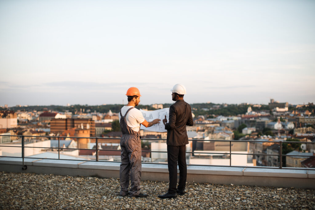 Commercial Roofing Experts on top of building looking at plan